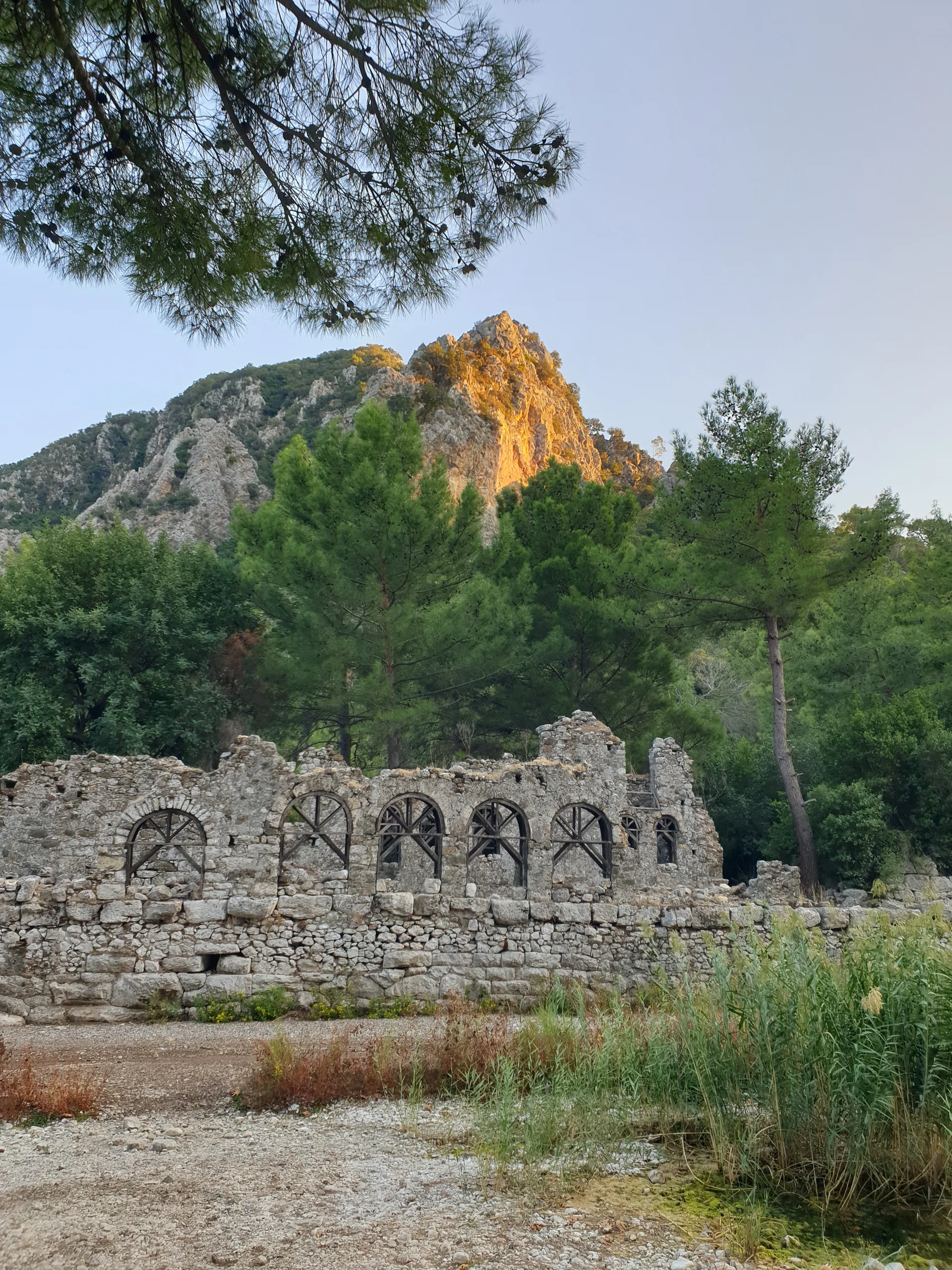 Rovine e pareti boscose a Olympos (foto d'archivio, 2021)