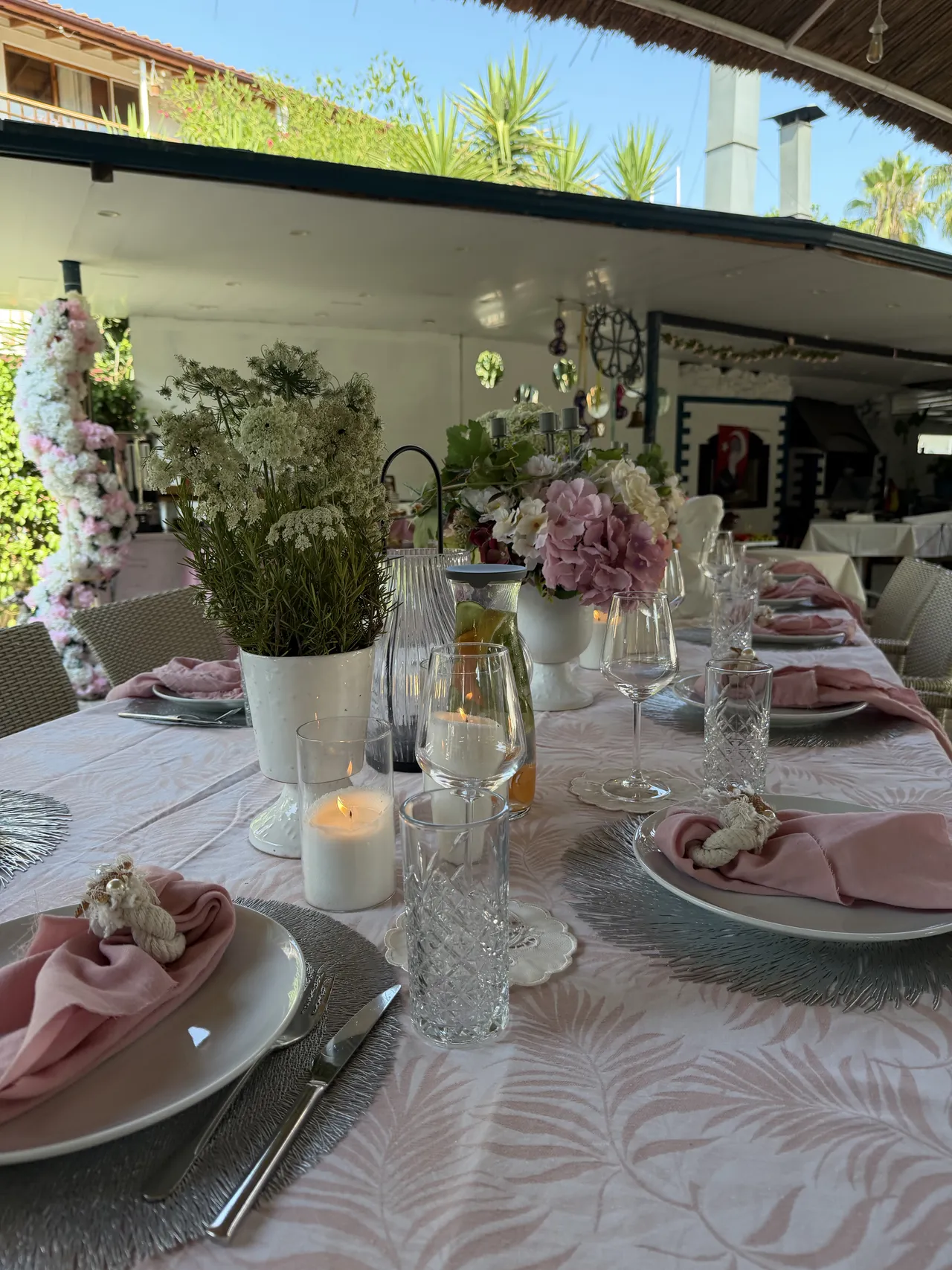A festive table with pink napkins and flowers in the Erendiz garden.